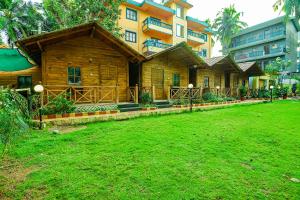a wooden house with a lawn in front of it at Via Jesant Valley Resort - Nr Candolim Beach in Candolim