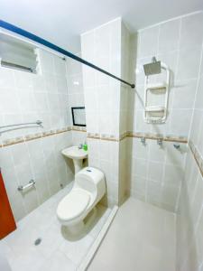 a white bathroom with a toilet and a sink at Casa fresca y amplia de 4 habitaciones in Cali