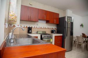 uma cozinha com um lavatório e um frigorífico de aço inoxidável em Casa de 4 habitaciones, excelente ubicación em Cali