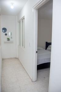 um quarto branco com uma cama e uma porta para um quarto em Casa de 4 habitaciones, excelente ubicación em Cali