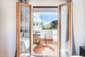 a glass door leading to a balcony with a table and chairs at Anemi Leros Apartments 1 in Panteli