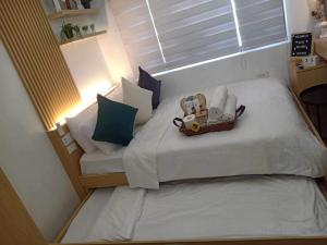 een kleine slaapkamer met een bed met een mand erop bij ALABANG STUDIO unit w/ high speed Fiber WIFI in Manilla