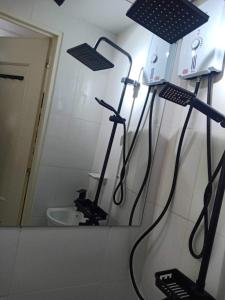 a bathroom with a shower with a mirror and a toilet at ALABANG STUDIO unit w/ high speed Fiber WIFI in Manila