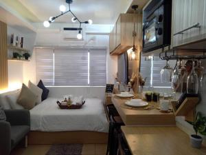 een kleine woonkamer met een bed en een tafel bij ALABANG STUDIO unit w/ high speed Fiber WIFI in Manilla