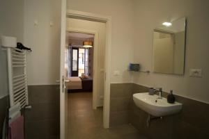 Donna Franca Rooms and Suite في باليرمو: حمام مع حوض ومرآة