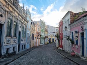 una calle vacía con edificios coloridos a ambos lados en Casa Versace Salvador - Colonial House, en Salvador
