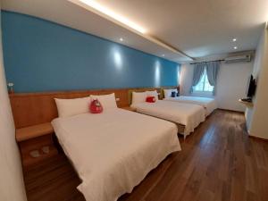 a room with two beds and a blue wall at 陽光小灣旅店 in Kenting