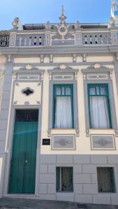 a building with two green doors and two windows at Casa Versace Salvador - Colonial House in Salvador