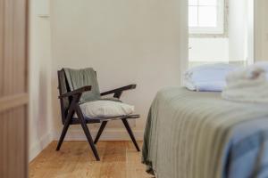 una silla sentada junto a una cama en una habitación en Sintra Unique, en Sintra