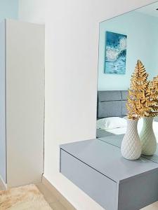 a bedroom with a dresser with two vases and a mirror at Bayu Temiang Seremban- Your Urban Retreat in Seremban