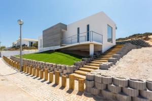 a house on the beach with a set of stairs at Villa Nooma in Carrapateira