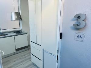 a kitchen with a refrigerator with the number three on it at Lisbon Ocean Apartments in Costa da Caparica