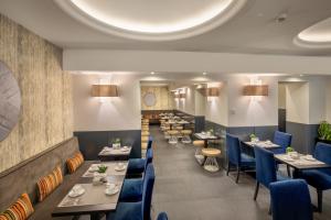 a dining room with tables and blue chairs at The Republic in Rome