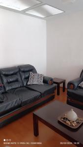 - un salon avec un canapé en cuir noir et une table dans l'établissement Departamento Seguencoma, à La Paz