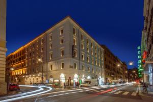 a large white building on a city street at night at The Republic in Rome