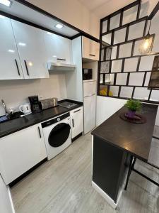 a kitchen with white appliances and a table in it at Cozy studio for 4 pax in Gran Via - M1 in Madrid