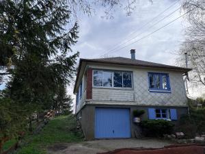 ein weißes Haus mit blauer Garage in der Unterkunft LES FERMES DE PINPIN - LE PAVILLON in Labaroche