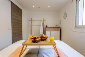 una mesa con dos vasos de zumo de naranja en una cama en Piscine- Jacuzzi - Vidéoprojecteur -Clim- Parking, en Mougins