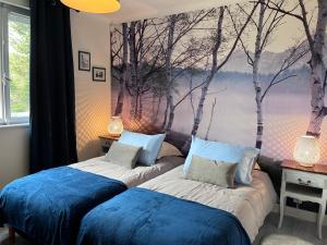 2 camas en una habitación con árboles en la pared en LES FERMES DE PINPIN - LE PAVILLON en Labaroche