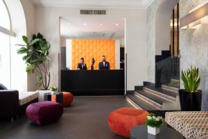 a lobby with three men in suits sitting at a podium at The Republic in Rome