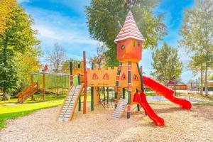 einen Spielplatz mit Rutsche und Rutsche in der Unterkunft Camping Le Parc de Paris in Villevaudé