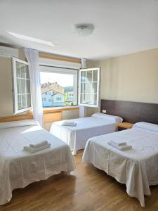 a room with two beds and a window at Pensión Pedrouzo in O Pedrouzo