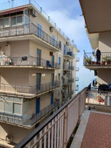a building with balconies and a man standing on a balcony at My Art home in Salerno