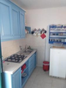 a kitchen with blue cabinets and a sink and a refrigerator at Kornati Robinson tourism in Kornati +23 photos