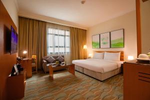 Habitación de hotel con cama y silla en Swiss-Belinn Doha en Doha