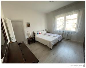 “Al 57”…. a quiet corner in Ferrara في فيرّارا: غرفة نوم بيضاء بها سرير ونافذة