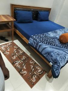 1 cama con edredón azul y mesa en Hotel Chandrasha Villa, en Ayodhya