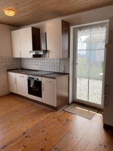 a kitchen with white appliances and a large window at Ferienwohnungen Schiffmann in Pressath