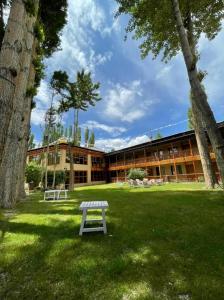 a picnic table in the grass in front of a building at Hotel Shambhala Resort in Leh