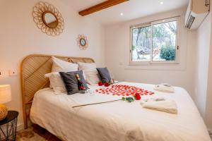Un dormitorio con una gran cama blanca con rosas. en Piscine- Jacuzzi - Vidéoprojecteur -Clim- Parking, en Mougins