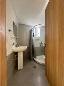 a bathroom with a sink and a shower and a toilet at Sea view Sarande in Sarandë +22 photos