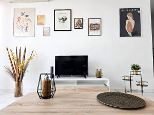 sala de estar con TV en una mesa blanca en Palm Haven Apartment, en St Paul's Bay