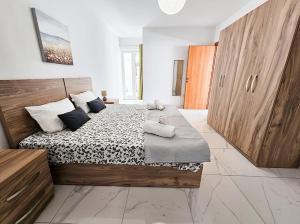 Un dormitorio con una cama grande con almohadas. en Palm Haven Apartment, en St Paul's Bay