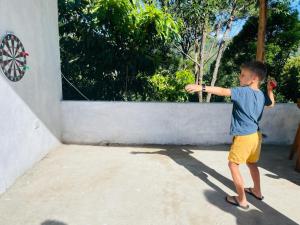 a young boy is playing with a kite on a wall at Rock n Fall Nature Resort in Ella
