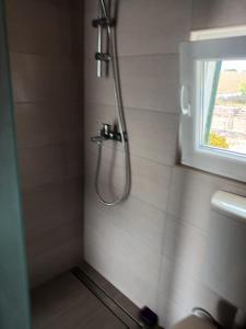 a shower in a bathroom with a window at Kornati Robinson tourism in Kornati