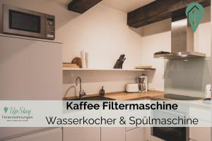 eine Küche mit Mikrowelle und Spüle in der Unterkunft Anna14 - Gulfhof Boomgaarden in Krummhörn