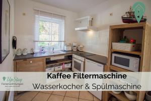 cocina con fregadero y microondas en Ferienhaus Max, en Greetsiel