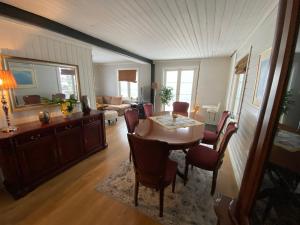 uma sala de jantar com mesa e cadeiras e uma sala de estar em Sentralt hus i Rjukan em Rjukan