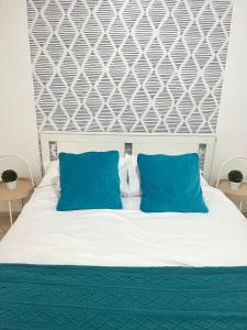 1 dormitorio con 1 cama con almohadas azules en Lovely apartment Taidia, en Maspalomas