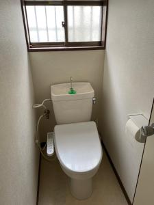a small bathroom with a toilet with a window at 大阪魔力民泊·岸里 in Osaka +1 photo