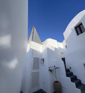 a white building with stairs and a blue sky at Blue Cave Oasis with Underground Jacuzzi in Megalokhori