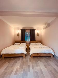 a room with three beds in a room at Villa Pich Boutique in Kampot
