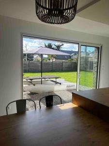 a dining room with a table and a view of a patio at La Villa Case-Bi in Saint-Germain-sur-Ay