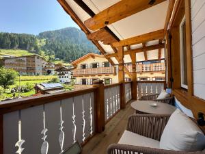 a balcony with chairs and a table and a view at B&B Family Accommodation Canazei BIKE FRIENDLY in Canazei