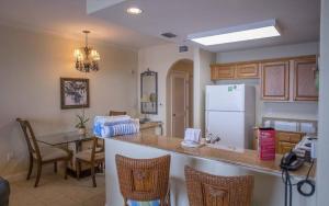 a kitchen with a table and a white refrigerator at Blue Heron Beach Resort in Orlando