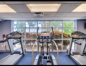 a gym with two tread machines and a large window at Blue Heron Beach Resort in Orlando